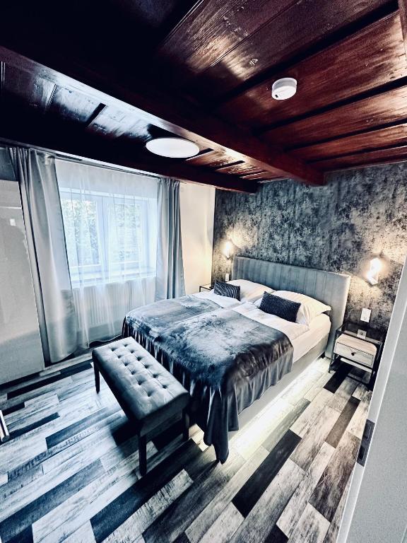 a bedroom with a bed and a bench in it at Trendy House 65 in Karácsond