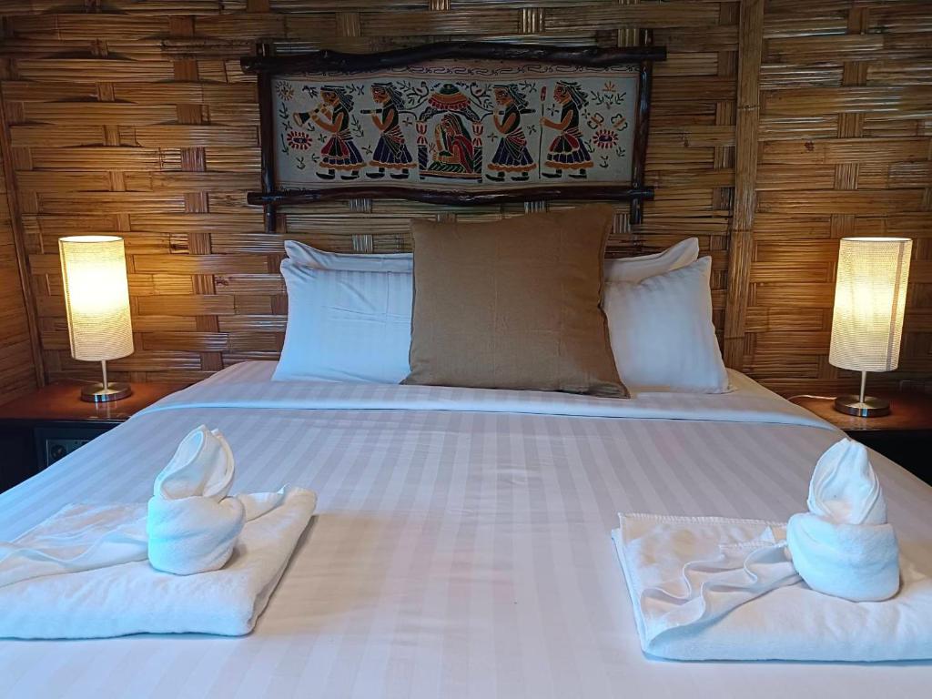 a bedroom with two towels on a bed with two lamps at Nangyuan Island Dive Resort in Ko Tao