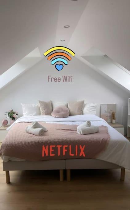 - une chambre dotée d'un lit avec un panneau netflix dans l'établissement Le cocon du Parisis, à Cormeilles-en-Parisis