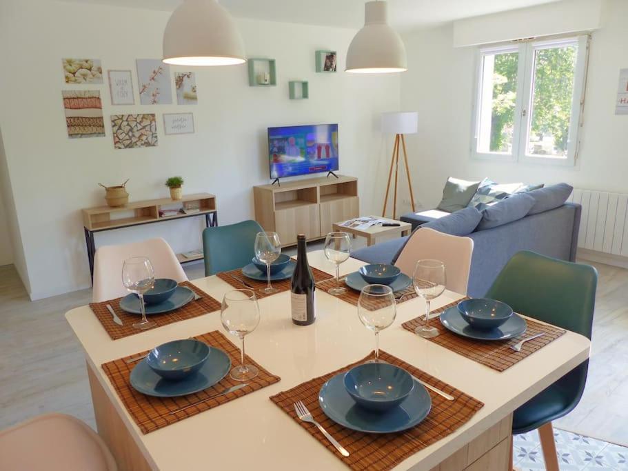 - un salon avec une table et des verres à vin dans l'établissement Appartement avec 2 chambres et parking privé, à Lille