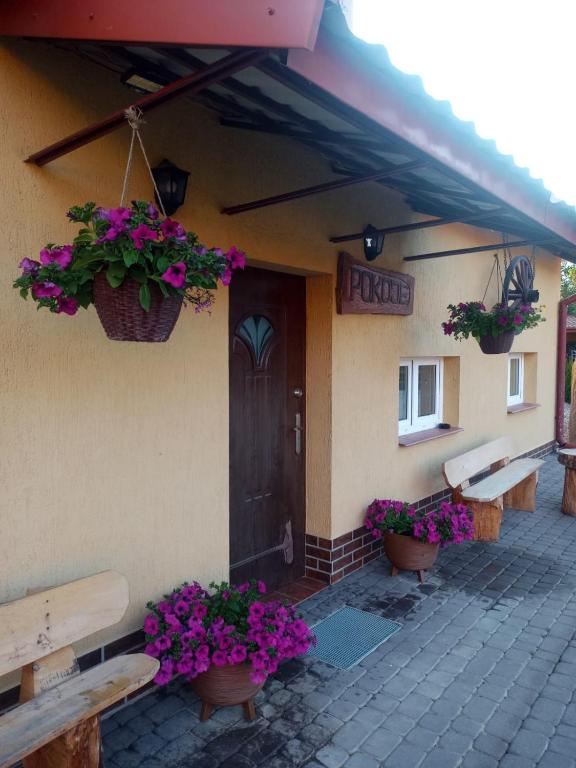 a building with benches and flowers in front of a door at Lorsby- wędkarska oaza in Mrągowo