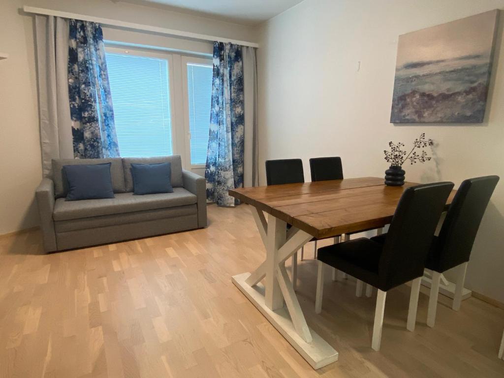 a dining room with a table and chairs and a couch at First Aparthotel Olive in Rovaniemi