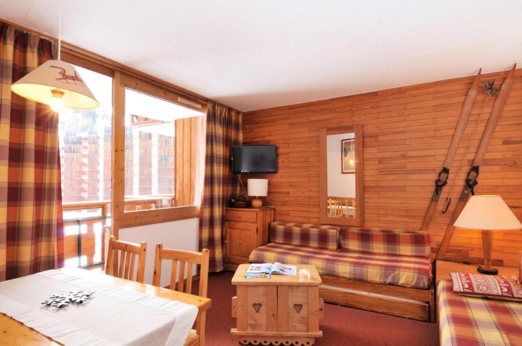 un salon avec un canapé et une table dans l'établissement Résidence Carroley A - 2 Pièces pour 5 Personnes 87, à Mâcot La Plagne