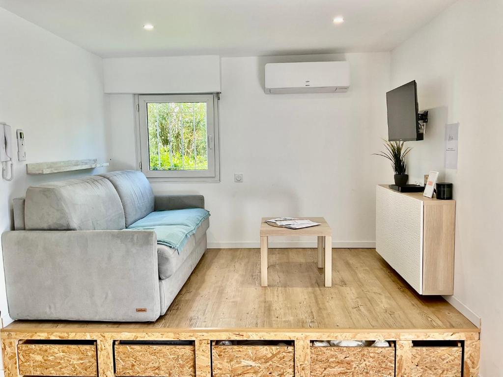 un salon avec un canapé et une table dans l'établissement Studio climatisé avec piscine, à Saint-Raphaël