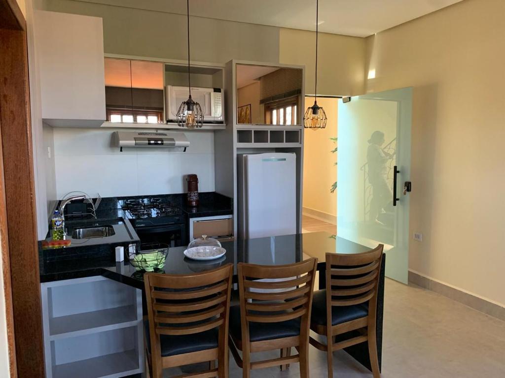 Una cocina con una mesa y sillas en una habitación. en Apartamentos Flat Maria, en Lençóis