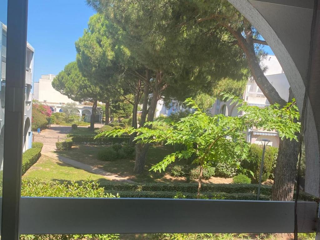- une vue sur un parc avec des arbres et des buissons dans l'établissement Magnifique studio avec loggia, au Grau-du-Roi