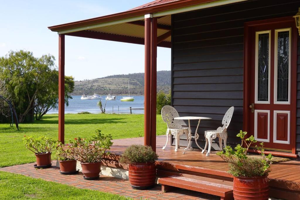 a porch of a house with a table and chairs at Casilda House-Central Waterfront in Dunalley