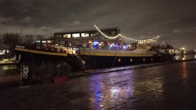 un grand bateau assis sur l'eau la nuit dans l'établissement Appartement Paris, à Paris