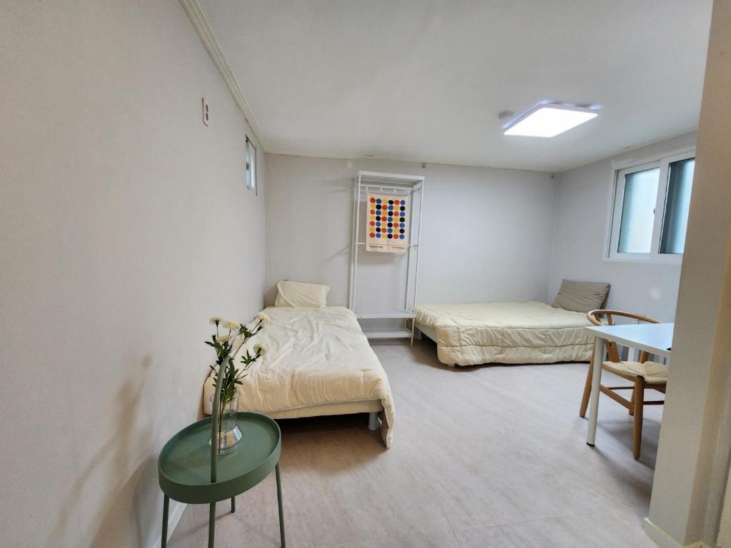 una camera con due letti e un tavolo di Goyo Stay a Uijeongbu