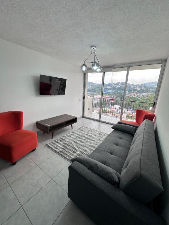 a living room with a couch and a large window at View 15, San Francisco Tower in San Salvador