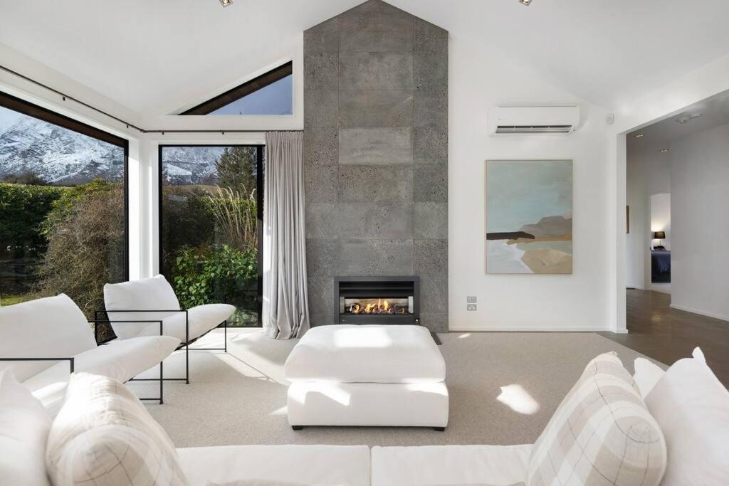 salon z białymi meblami i kominkiem w obiekcie Skye Scape Luxury Retreat - Mountain Views w mieście Frankton