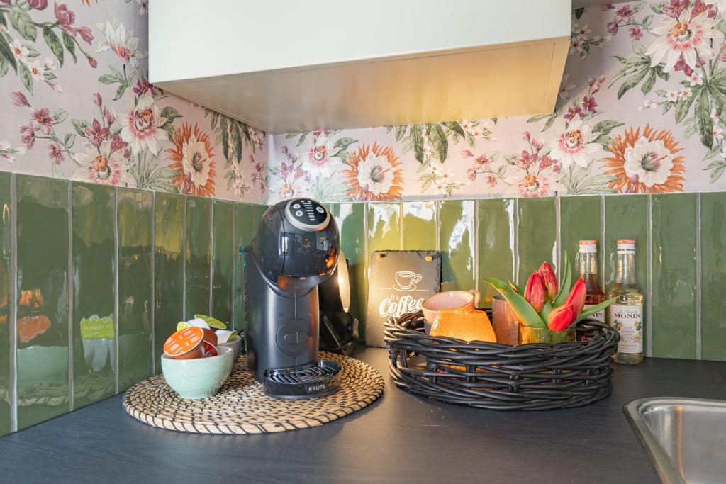 a kitchen counter with a juicer and a basket of fruit at B&B de Groene Poort in Stein