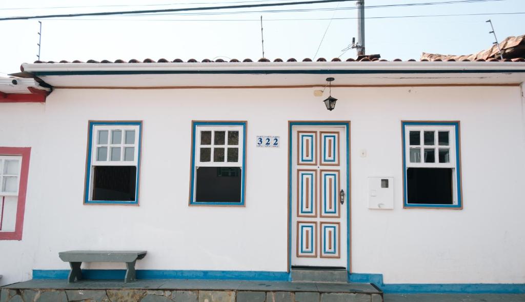 a white house with a bench in front of it at Hospedagem Rancho Fundo in Diamantina