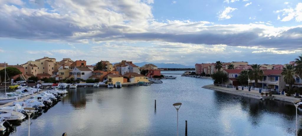 - une vue sur une rivière avec des bateaux dans une ville dans l'établissement Studio avec vue sublime sur l'étang et les montagnes catalanes, au Barcarès