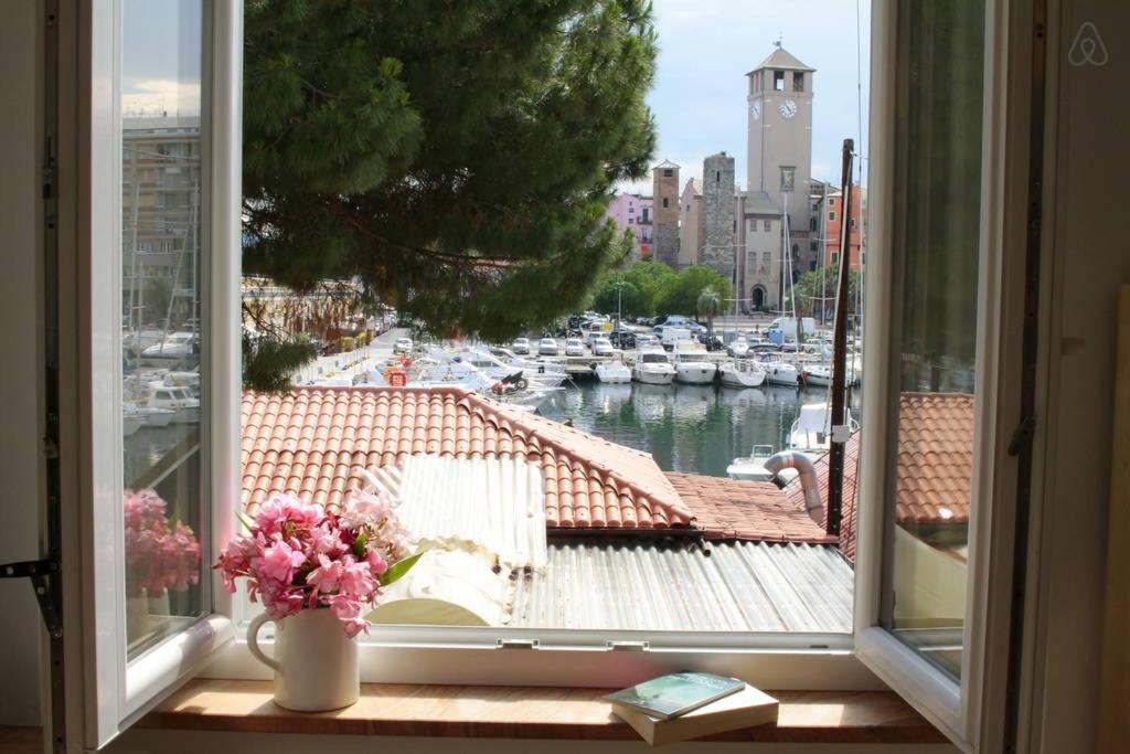a window with a view of a marina with boats at Darsena Apartments in Savona