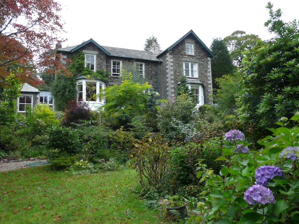 una casa antigua con un jardín delante de ella en Annesdale House en Windermere