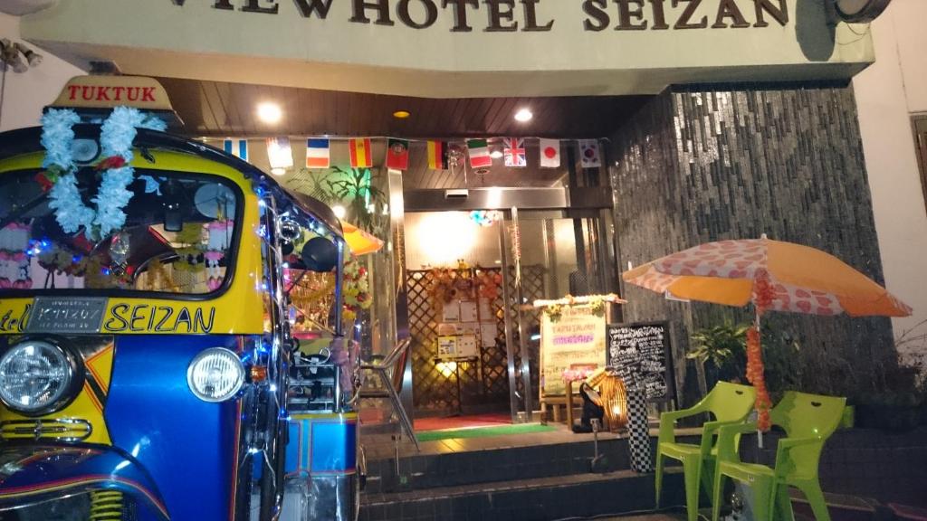 una furgoneta estacionada frente a un hotel con un paraguas en Onomichi View Hotel Seizan en Onomichi