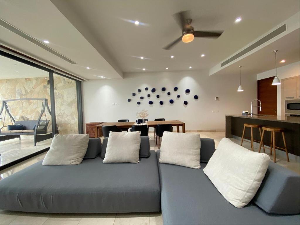 a living room with a blue couch and a table at Arena Bca in Cruz de Huanacaxtle