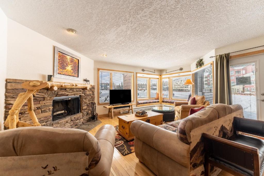 a living room with two couches and a fireplace at Willows #1704 in Keystone