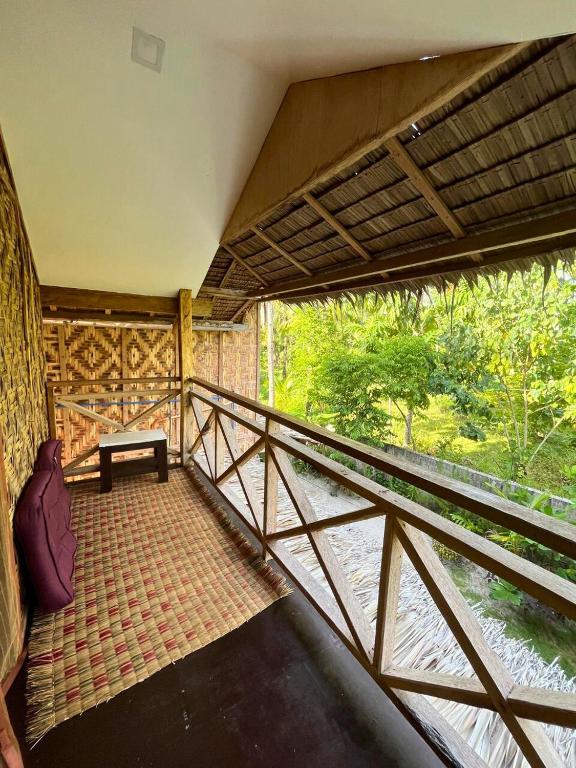 a balcony of a house with a bench on it at Bulkan Villa Rental in General Luna