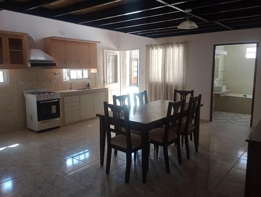 a kitchen with a dining room table and chairs at Morada Romana in Rivadavia