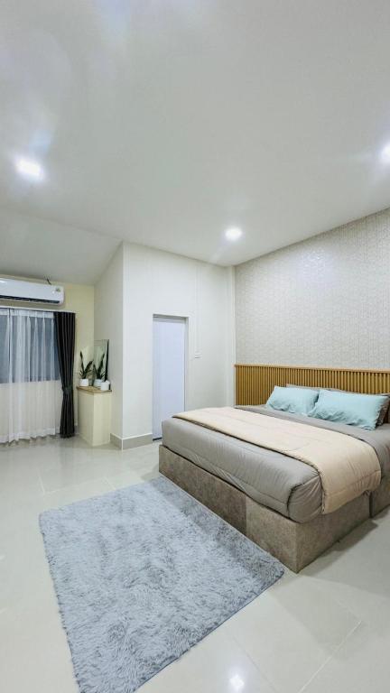 a bedroom with a large bed and a rug at Vela house hatyai 2 in Hat Yai