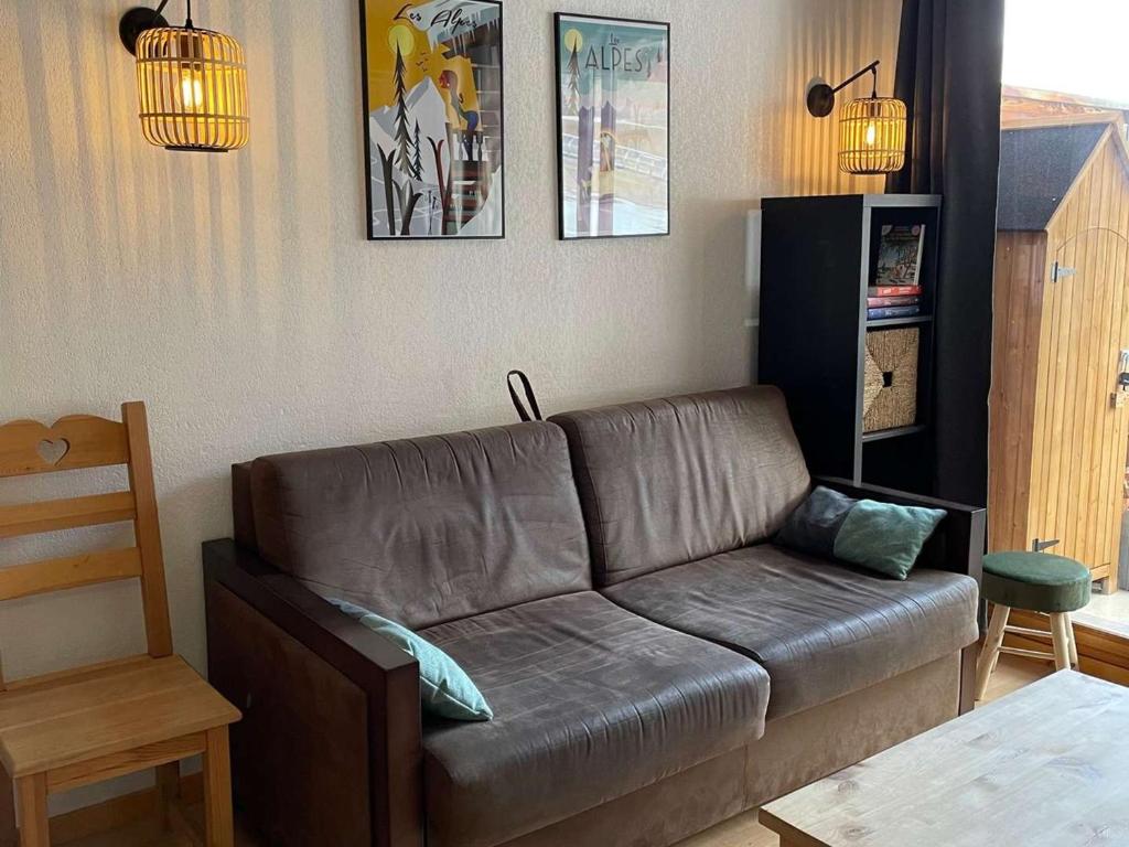 un salon avec un canapé en cuir et une table dans l'établissement App. skis aux pieds avec piscine, balcon et WiFi - FR-1-322-646, aux Orres