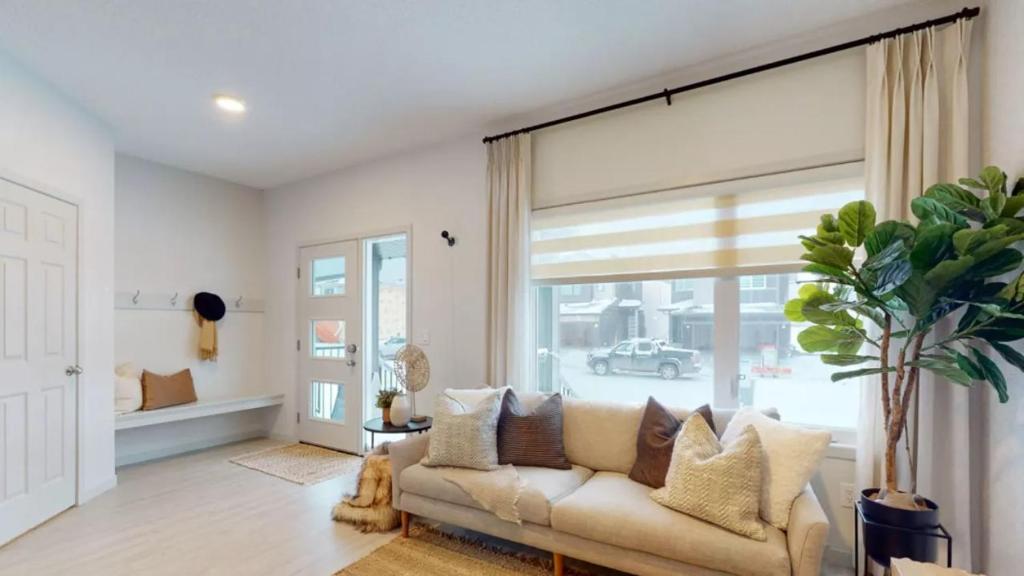 un soggiorno con un divano e una grande finestra di Exquisite 3bedroom home, 16m to WEM & 25m to YEG a Edmonton