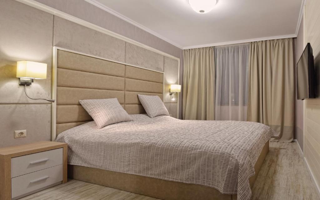 a bedroom with a large bed with a large headboard at Divona Studio in Ruse