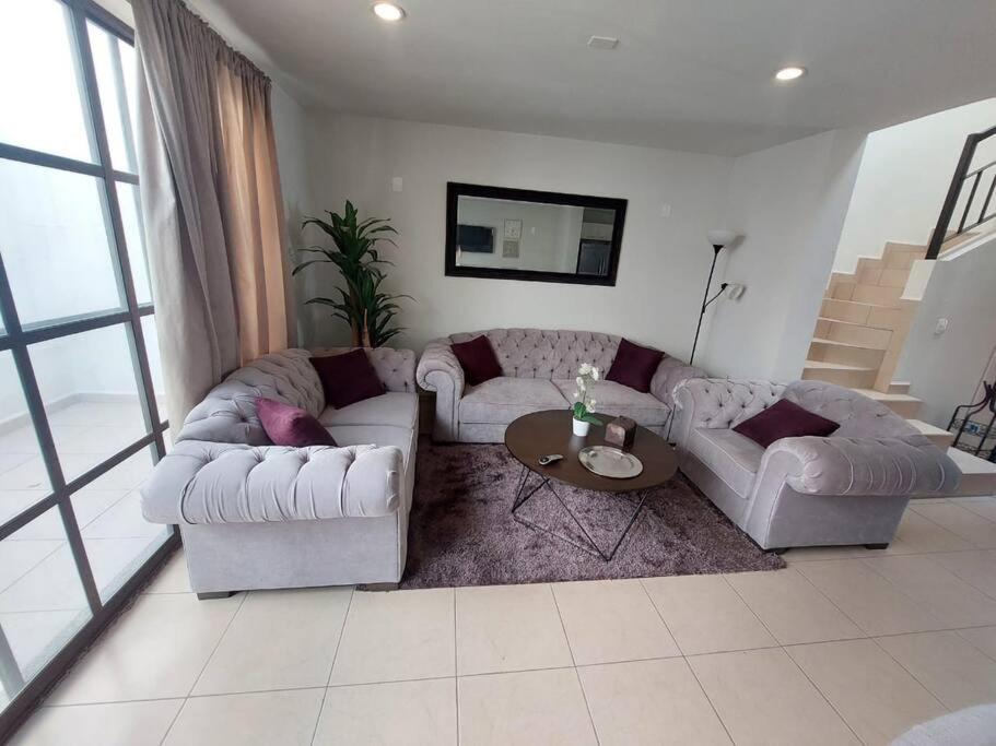 a living room with two couches and a table at Encantadora Casa en La Yesca cerca de poliforum in Santa Julia