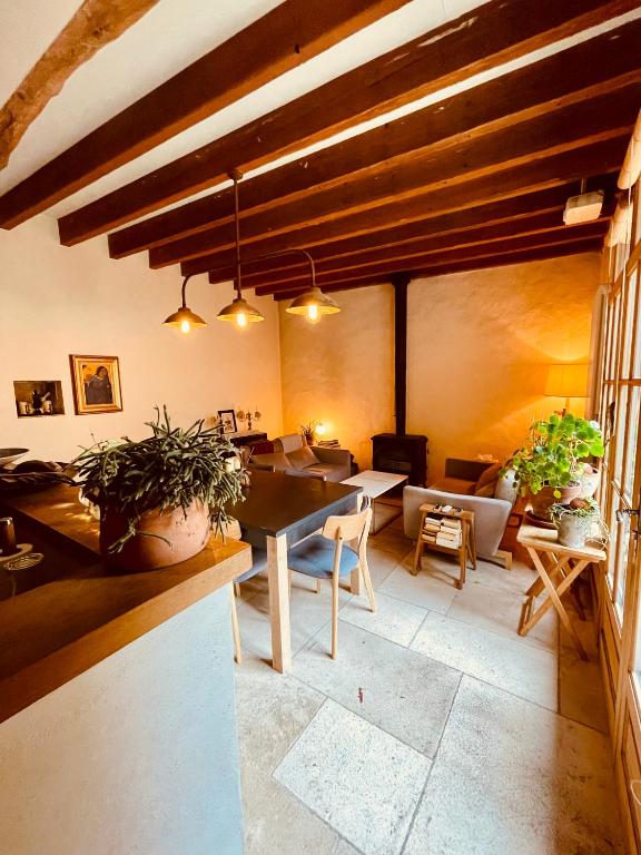 une salle à manger avec une table et des chaises dans une pièce dans l'établissement Maison de Vignerons La Grange, à Noyers-sur-Serein
