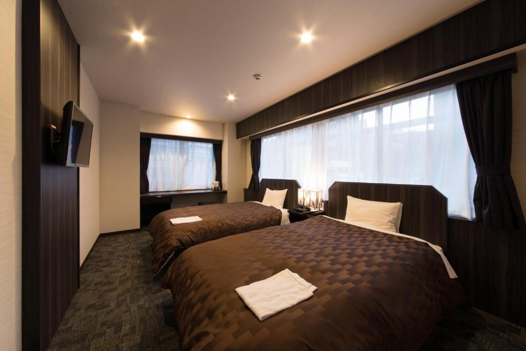 Postel nebo postele na pokoji v ubytování Hotel Taisei Nakanoshima