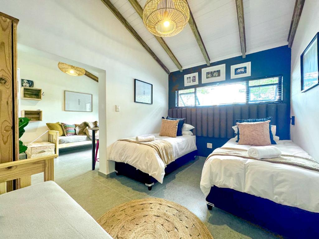 a bedroom with two beds and a couch at Amsterdam Suite in Cape Town