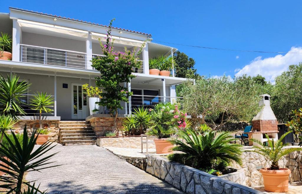 a house with a lot of plants in front of it at 1 Haus Linden Osljak in Island Osljak