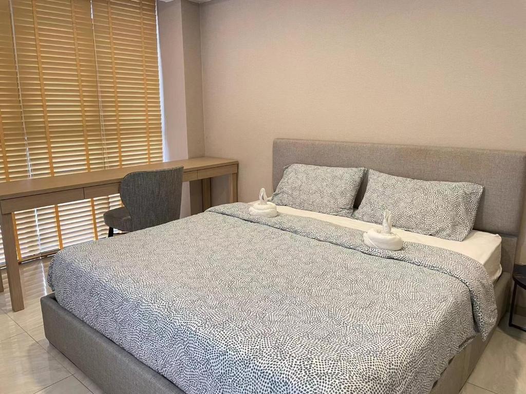 Un dormitorio con una cama y un escritorio y una ventana. en Botique condo in Asoke, en Bangkok