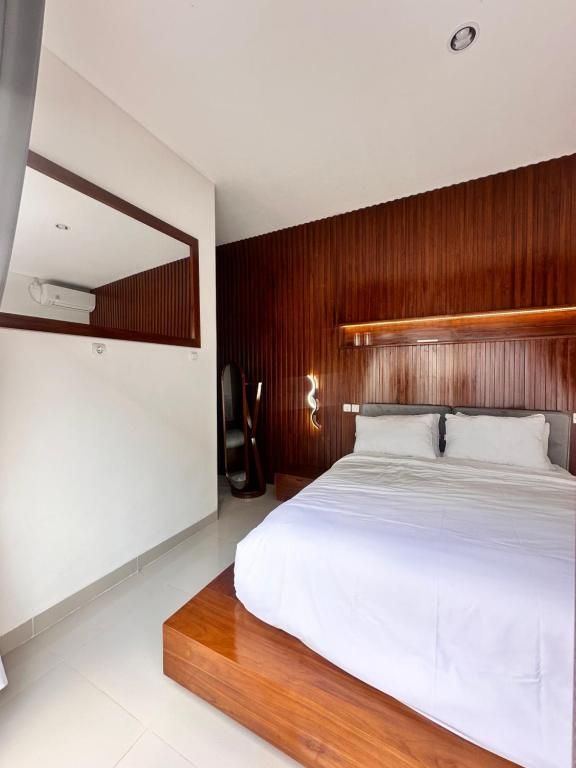 a bedroom with a large bed with a wooden headboard at Jimbaran in Jimbaran