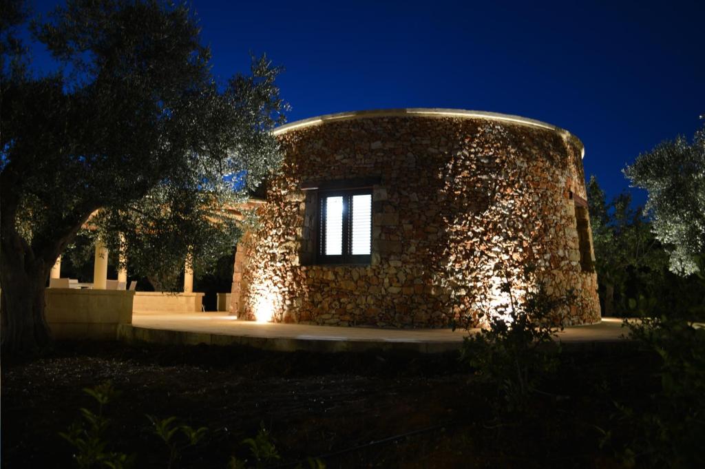 a stone building with lights on it at night at Li Furneddhri (Trulli) in Casarano