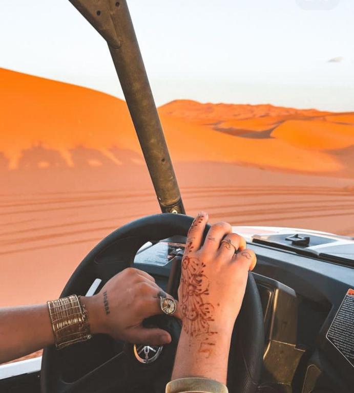 a woman driving a car in the desert at Merzouga Desert Campsite &Activities in Merzouga