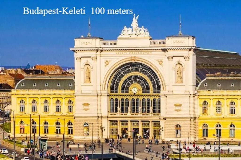 a large yellow building with people in front of it at Centre Sunshine Bedroom Room Season 5 in Budapest