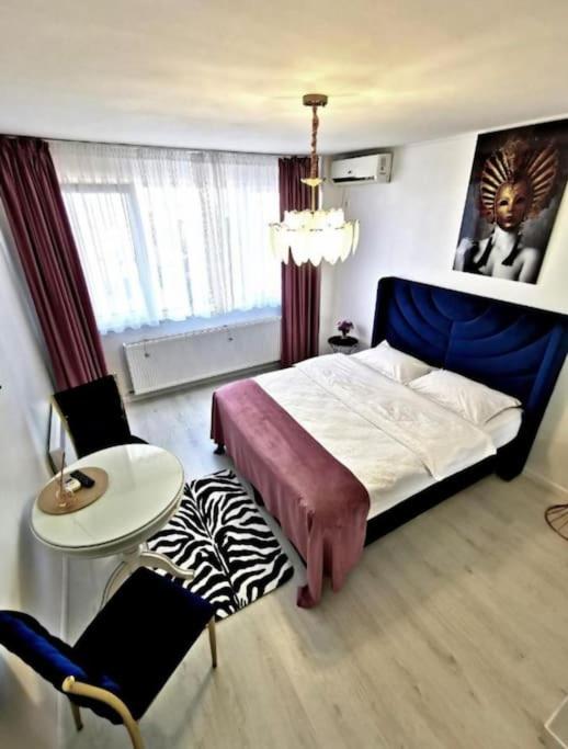 a bedroom with a bed and a table and chairs at Studio Maria in Galaţi