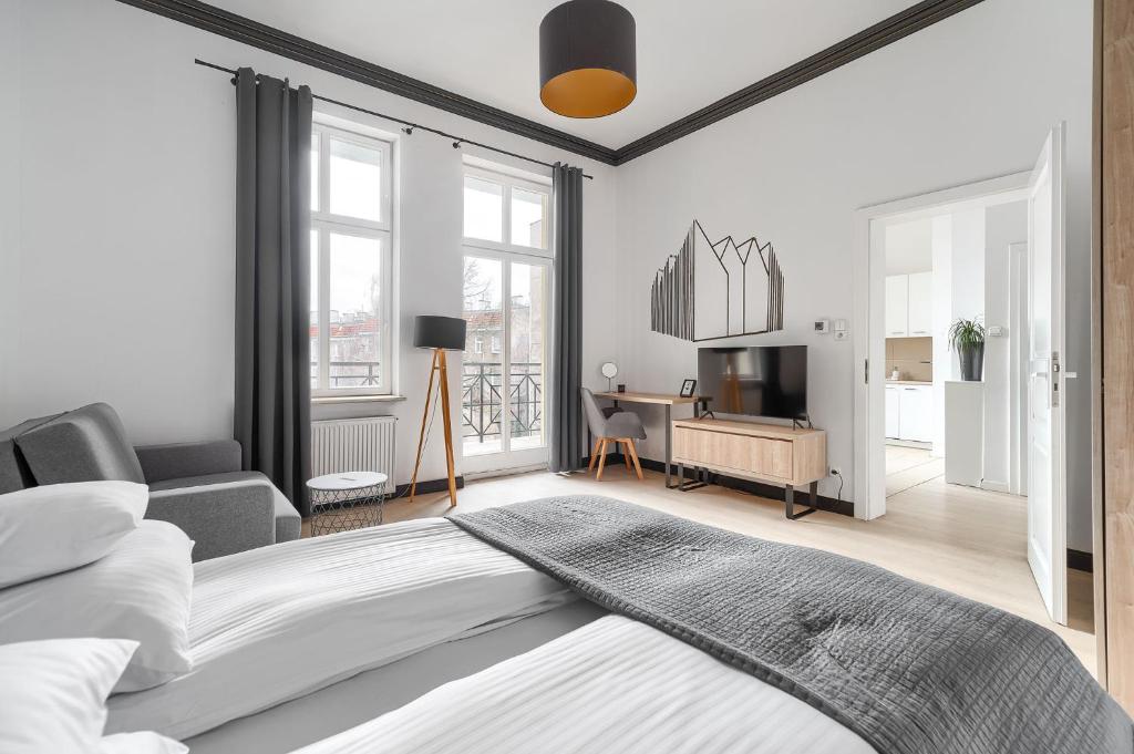 a bedroom with a bed and a living room at Aparthotel Platinum in Szczecin