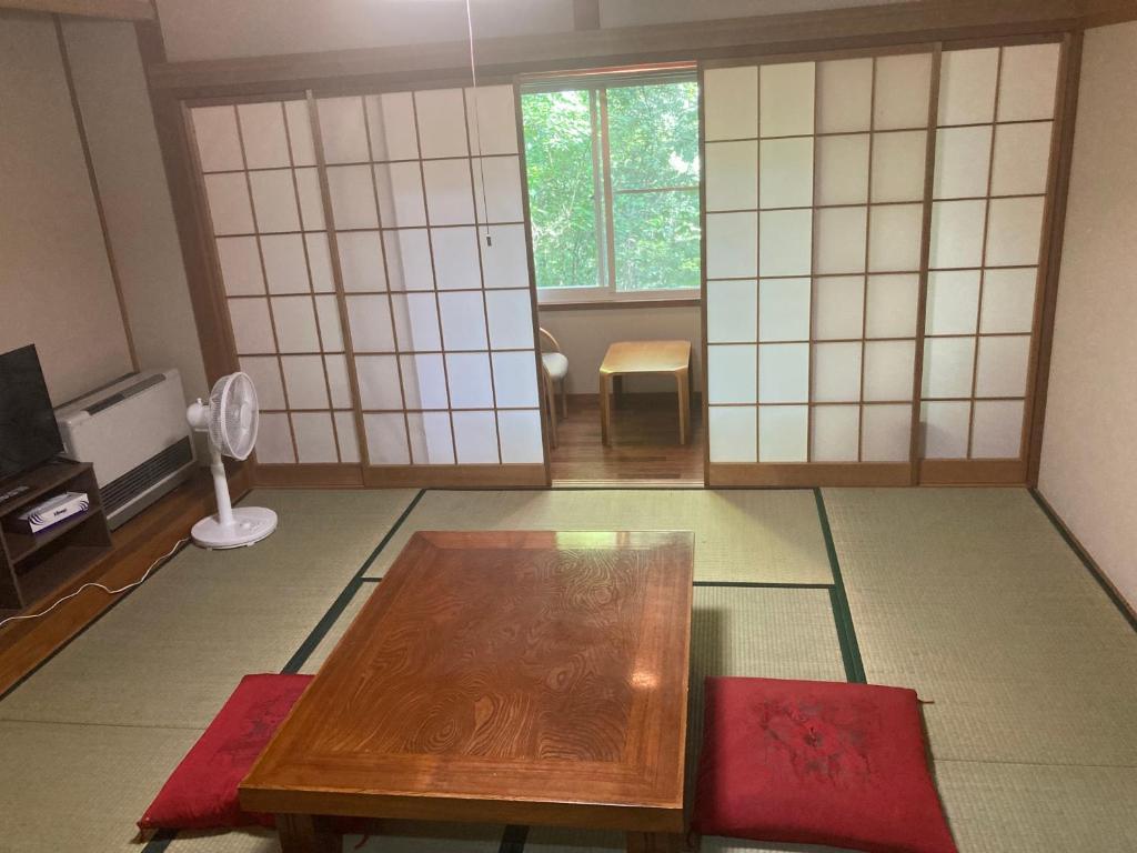 軽井沢町にある余裕堂軽井沢山荘のテーブルとテレビのあるリビングルーム