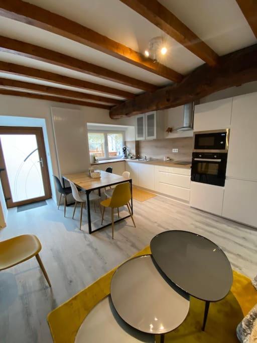 - une cuisine avec deux tables et des chaises dans une pièce dans l'établissement Jolie maison de campagne à la ville chez TINAT, à Trégueux