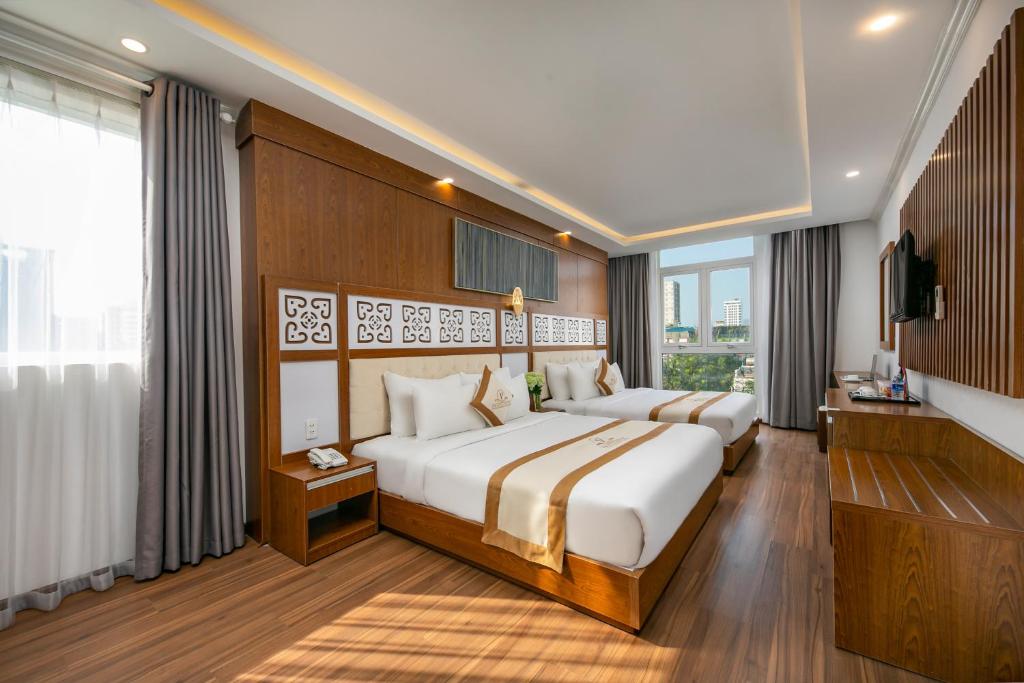 Postel nebo postele na pokoji v ubytování Prague Da Nang Beach Hotel