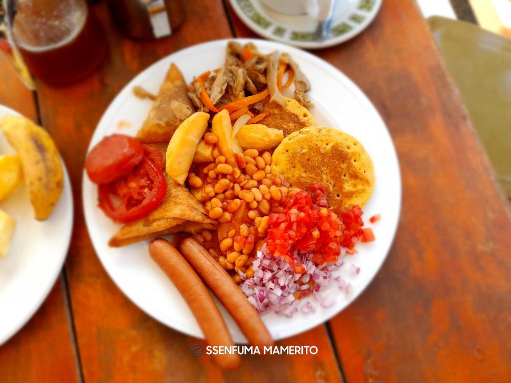 a plate of food with corn salsa and other foods at Pearl Motel Wing in Mukono