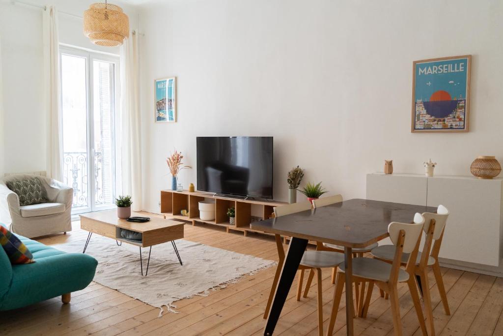 un salon avec une table et une télévision dans l'établissement JULIEN - Gare St Charles - Cours Julien, à Marseille