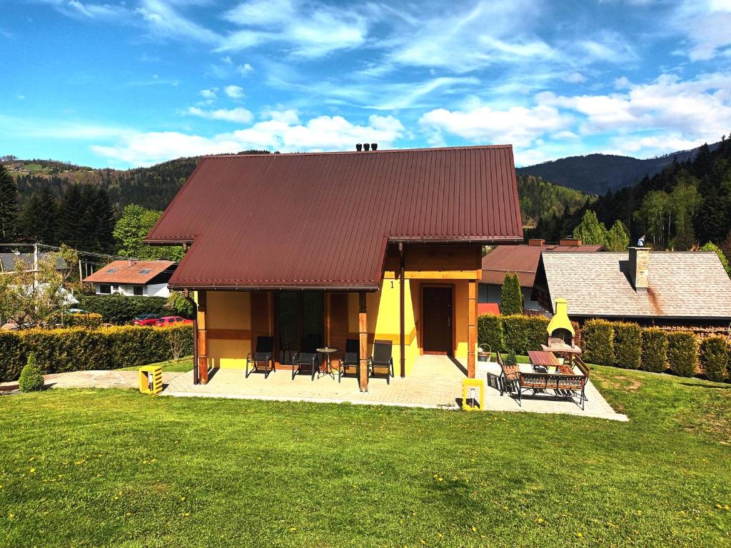a house with a red roof on a green lawn at Cicha Chata Szczyrk in Szczyrk