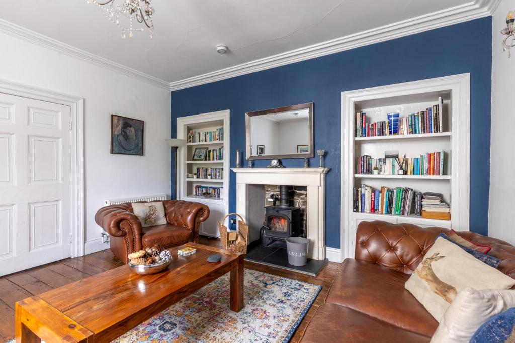 a living room with a couch and a fireplace at Salvin House - North East Escapes in Alston