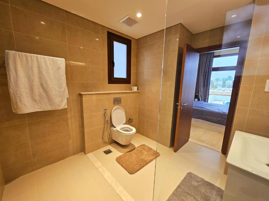 W łazience znajduje się toaleta i przeszklony prysznic. w obiekcie Luxury Villa with Private Pool and Lagoon view w mieście Salala