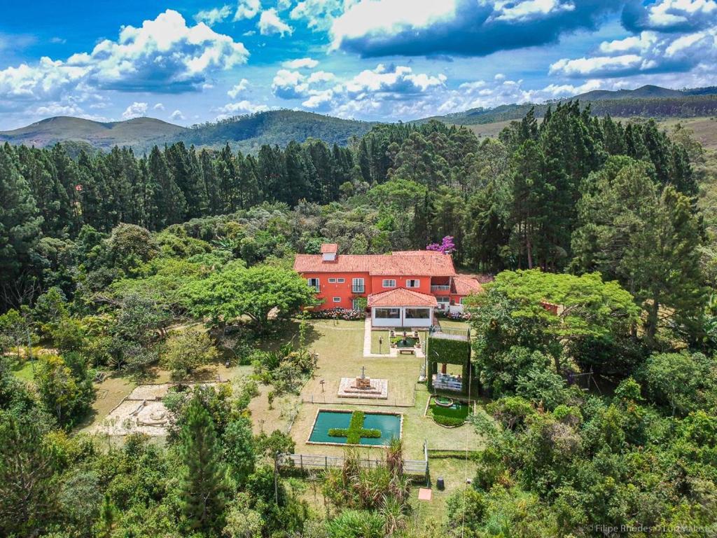 an aerial view of a red house in the forest at Caminho das Lavras in Lavras Novas